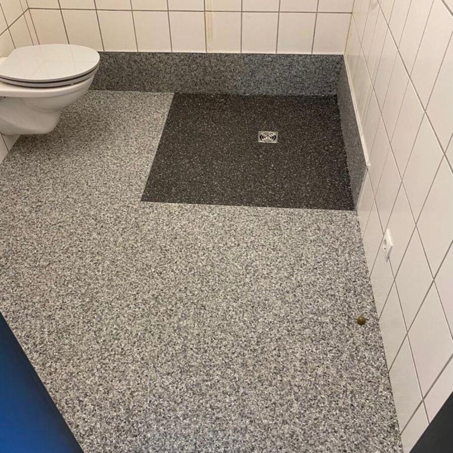 Badezimmer: neuer Steinteppich auf dem Boden, die vorhandenen Wandfliesen bleiben erhalten